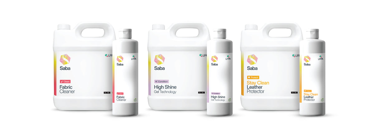 Four white plastic bottles of Saba leather and fabric care products arranged in two groups of two on a plain white background. The labels show Saba branding with product names including Fabric Cleaner, High Shine Gel Technology, and Leather Protector.